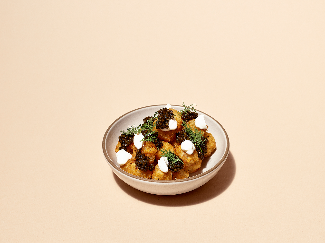 a bowl of food with caviar and sour cream on top