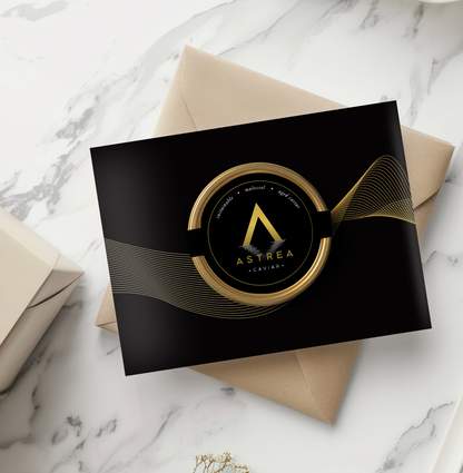 an Astrea Caviar greeting card is on top of a brown box sitting on a marble table