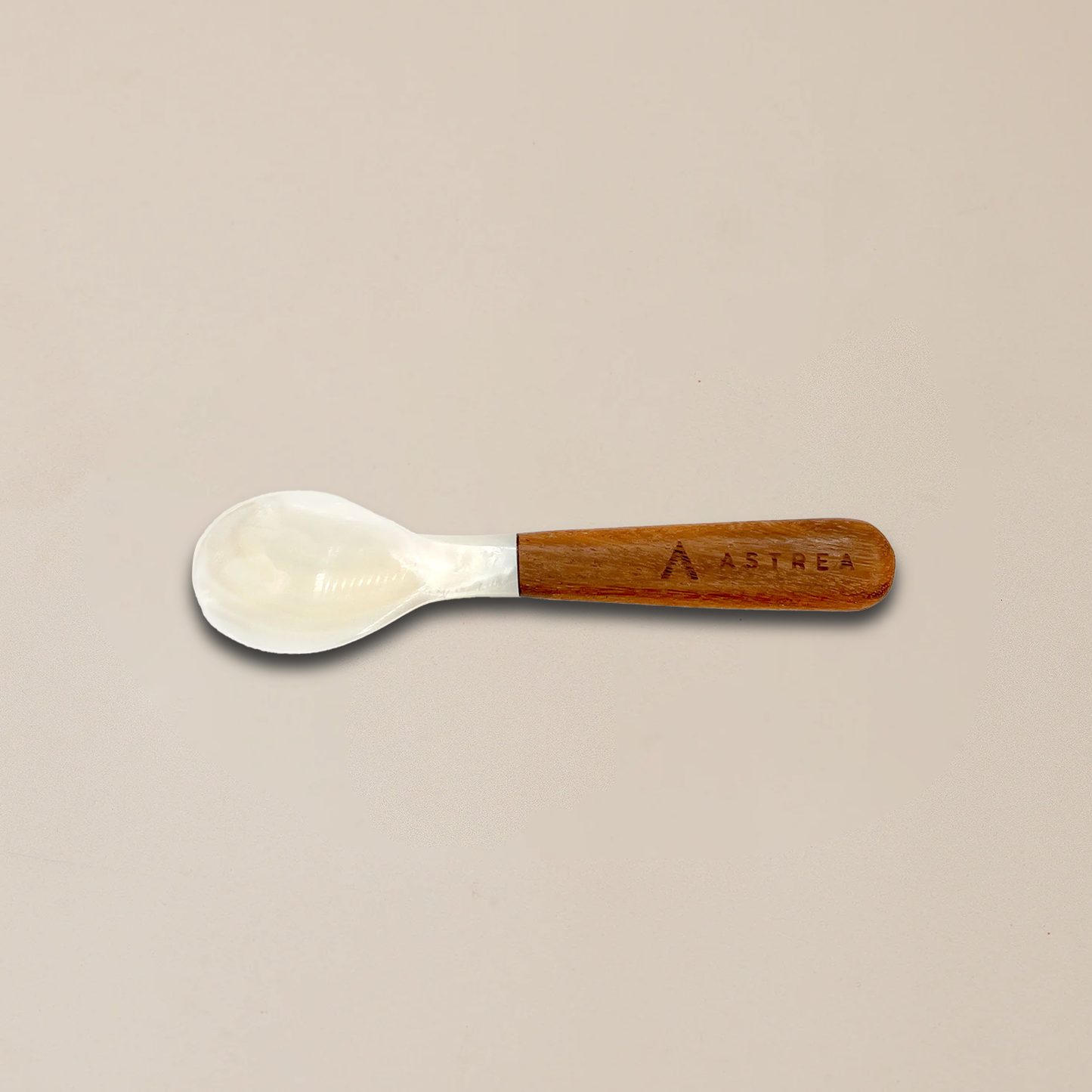 a white spoon with a wooden handle that says astrea on it